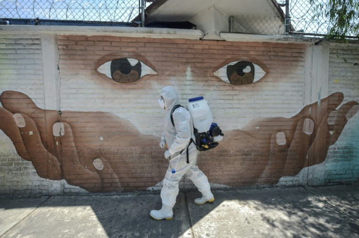 A cleaning worker disinfects a street in Mexico City