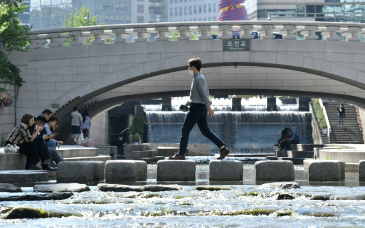 A man wearing a face mask crosses a stream in Seoul on May 6