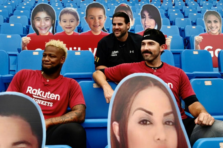 Rakuten Monkeys players (from L to R) Lisalverto Bonilla, Elih Villanueva, and Ryan Carpenter sit among life-size cutouts depicting fans