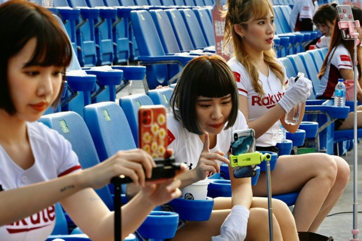 Cheerleaders are using their phones to interact with fans