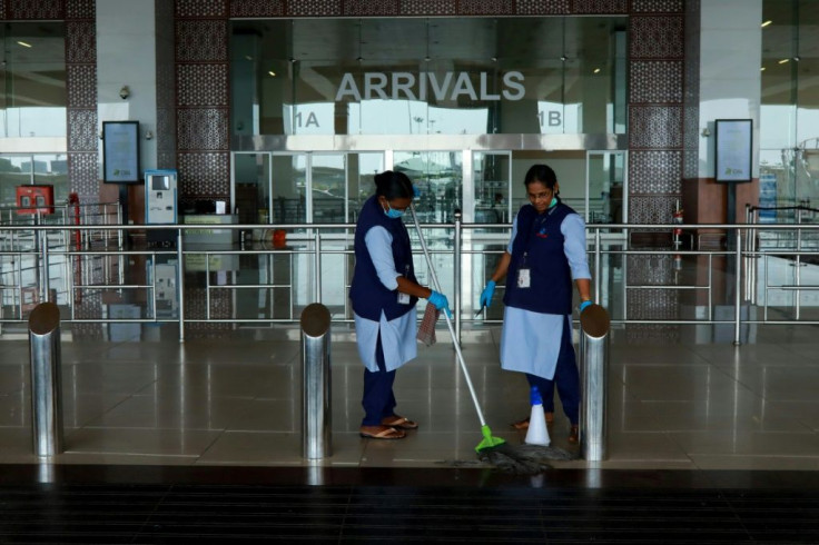 Staff clean the arrivals terminal at Cochin International Airport in Kochi ahead of the arrival of a first repatriation flight carrying Indian citizens from the Gulf