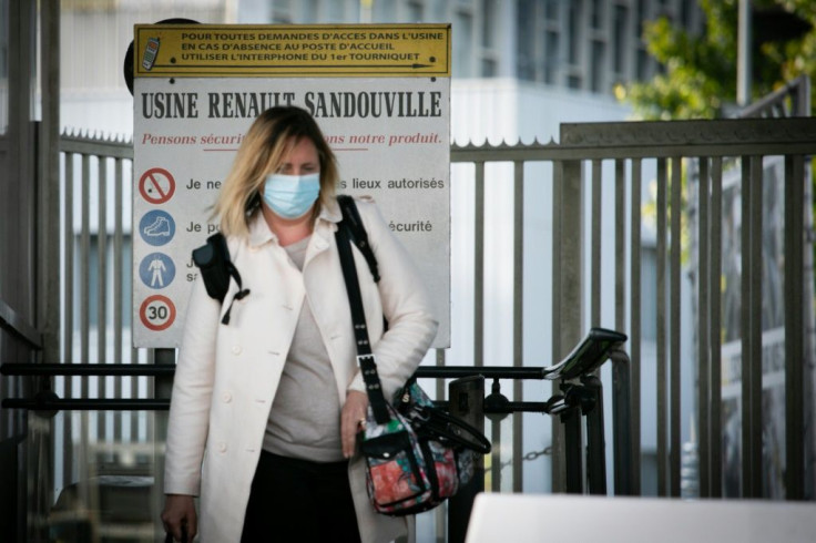 A woman wearing a face mask leaves the plant of the French Renault car maker in Sandouville, northern France, on May 7, 2020; the Le Havre judiciary courthouse has said French car maker Renault must suspend a return to production during the COVID-19 pande