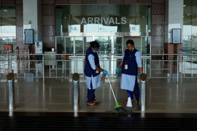 Staff clean the arrivals terminal at Cochin International Airport in Kochi ahead of the arrival of a first repatriation flight carrying Indian citizens from the Gulf