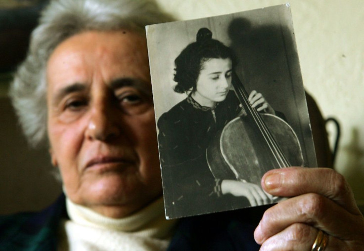 Holocaust survivor Anita Lasker-Wallfisch, pictured here in 2005, holds up a portrait of herself playing the cello in Berlin before World War II