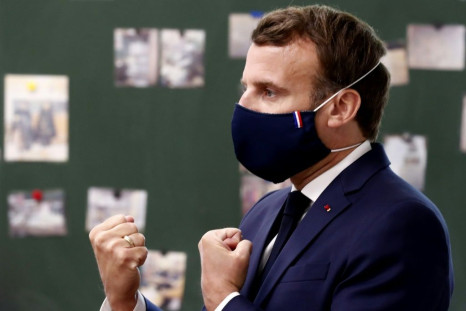 President Emmanuel Macron sporting a mask adorned with the red, white and blue of the French flag during a school visit.