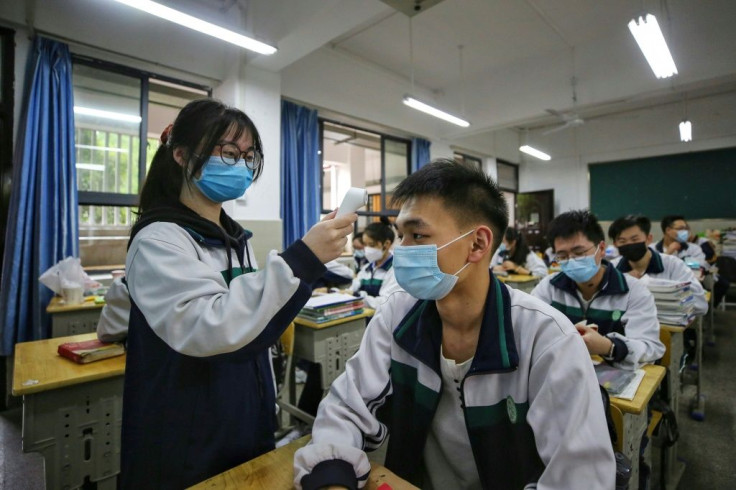 A high school senior checked a fellow student's temperature in Wuhan, China, this week as the city's schools reopened for the first time since January.