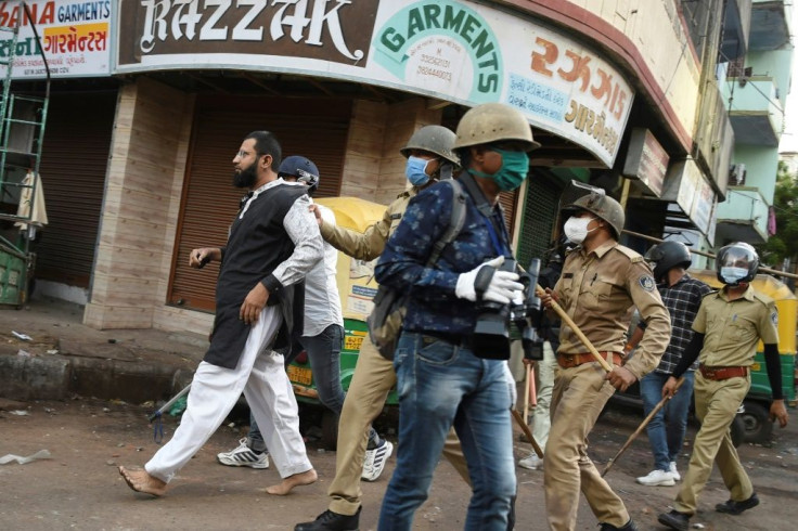 Gujarat police detain a man after he threw stones at them during a government-imposed nationwide lockdown in Ahmedabad on May 8, 2020