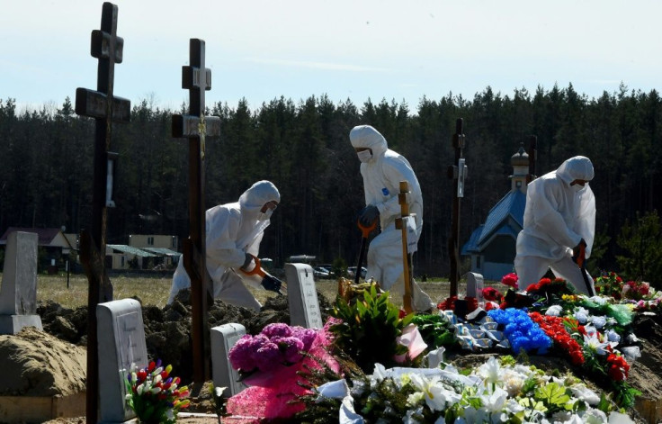 Cemetery workers wearing protective gear bury a coronavirus victim at a cemetery on the outskirts of Saint Petersburg on May 6, 2020