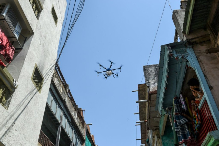 People in Ahmedabad in India - a new virus hotspot - watch from their balcony as a drone sprays disinfectant