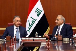 Iraqi Prime Minister Mustafa Kadhemi (L) sits next to outgoing premier Adel Abdel Mahdi during a meeting with members of the new government in Baghdad on May 7, 2020