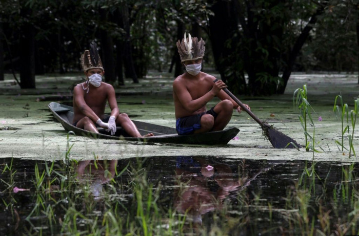 Satere-mawe indigenous men navigate the Ariau River during the coronavirus pandemic at the Sahu-Ape community located some 80 kilometers from Manaus in Amazonas State on May 5
