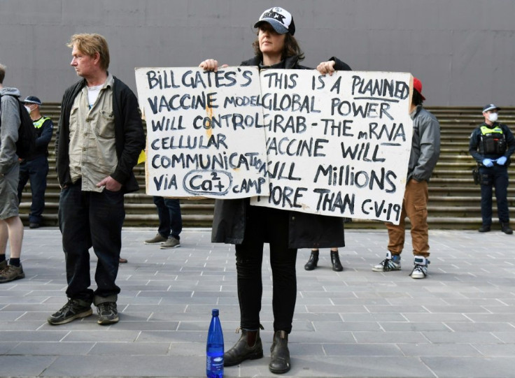 An anti-lockdown protester holds placards on the steps of Victoria's state parliament in Melbourne