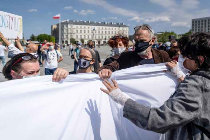 Protestors in Warsaw hold a huge piece of white fabric as a symbol of the disfunction in Poland on the day it was supposed to hold a presidential election