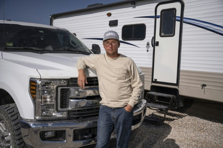 Clenon Weaver, 34, a welding inspector from Texas, poses with his truck and trailer on May 6, 2020 in Carlsbad, New Mexico; like many other oil-field workers, a sharp drop in prices has left his future unclear