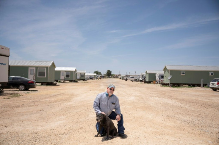 Michael Garner, who manages an RV park outside Carlsbad, New Mexico, poses with his dog, Pretty Girl, on May 8, 2020; Garner has lost about 30 tenants as the sharp drop in oil prices has led to petroleum-sector layoffs