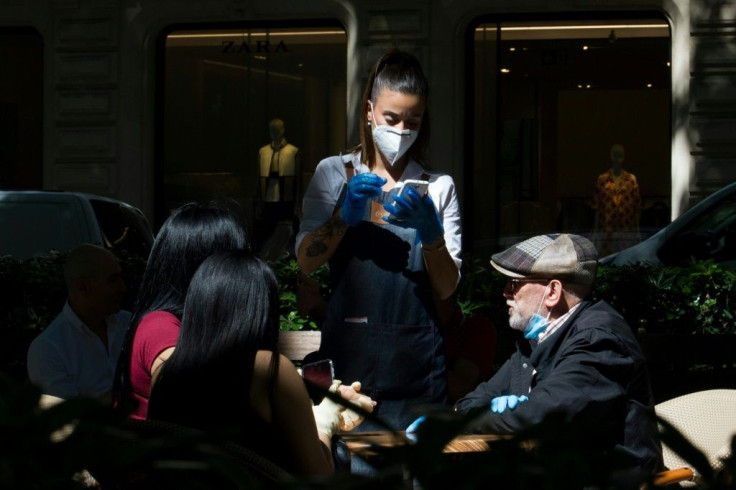 A waitress takes orders at a restaurant in Palma de Mallorca as Spain enacts the start of a phased transition through to the end of June