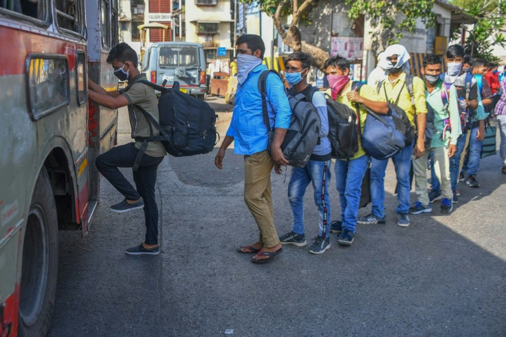 Migrant workers board a bus outside Dharavi slums in Mumbai