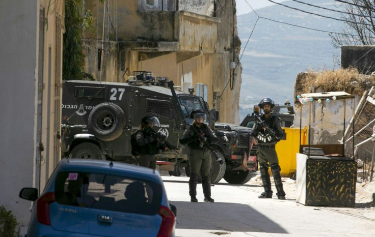 Israeli soldiers hunt for the Palestinian stonethrower believed to be responsible for the death of a comrade during an arrest operation in the village of Yaabad in the occupied West Bank