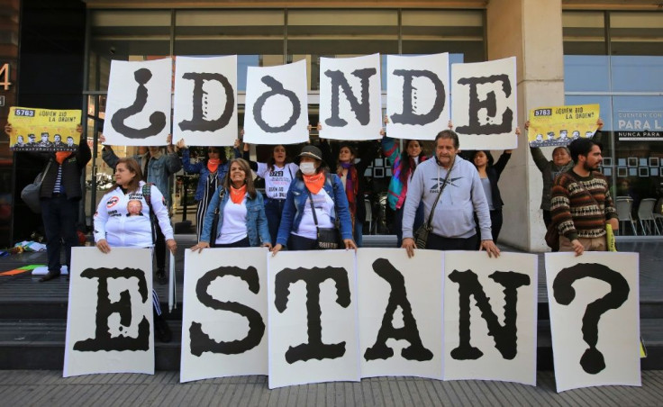 Protesters demonstrate against extrajudicial killings in front of the building housing the Special Jurisdiction for Peace body