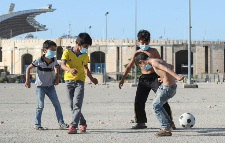 Mask-clad boys play football in the Lebanese capital Beirut