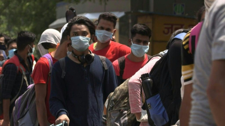 Passengers line up to enter New Delhi railway station as India partially resumes train services as part of lockdown easing measures