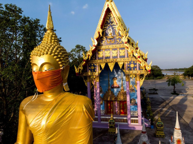A face mask was placed on the face of a giant Buddha statue outside Bangkok