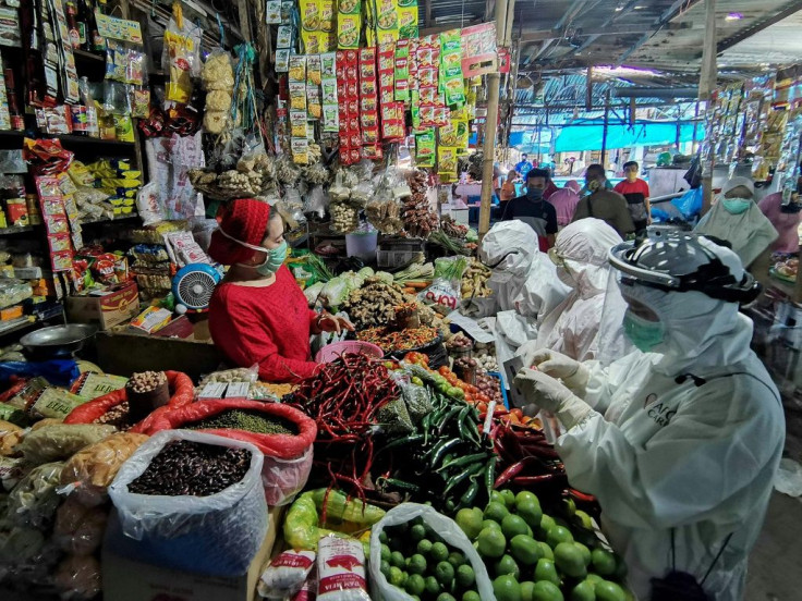 Medical staff take a blood sample from a vendor at a market in Makassar, Indonesia