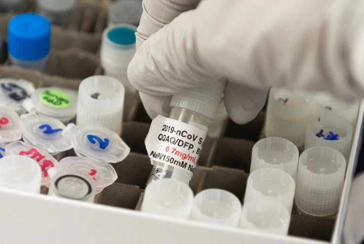 At Novavax labs in Rockville, Maryland, Dr. Nita Patel, Director of antibody discovery and vaccine development, lifts a vial with a potential COVID-19 vaccine.