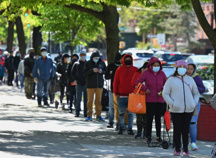 People wait in line as members of the US Army National Guard hand out food and other essentials for people in need at a food pantry in the Brooklyn borough of New York