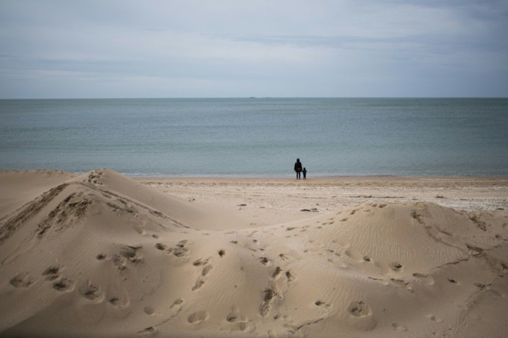 People enjoy a walk on the the beach in La Baule, western France after lockdown measures were eased