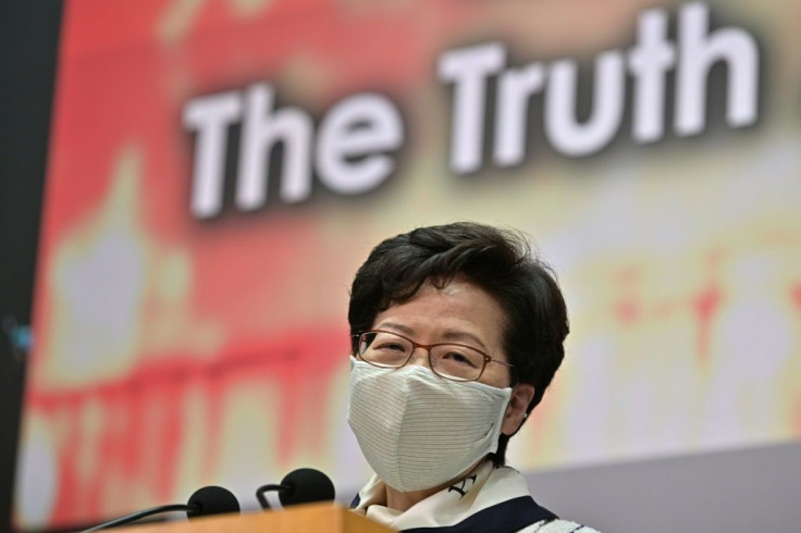 Carrie Lam spoke in front of a backdrop filled with pictures of violent protests alongside the slogan 'The Truth About Hong Kong'