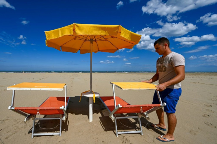 A beach manager spaces out sunbeds on the seafront of Cesenatico on the Adriatic coast