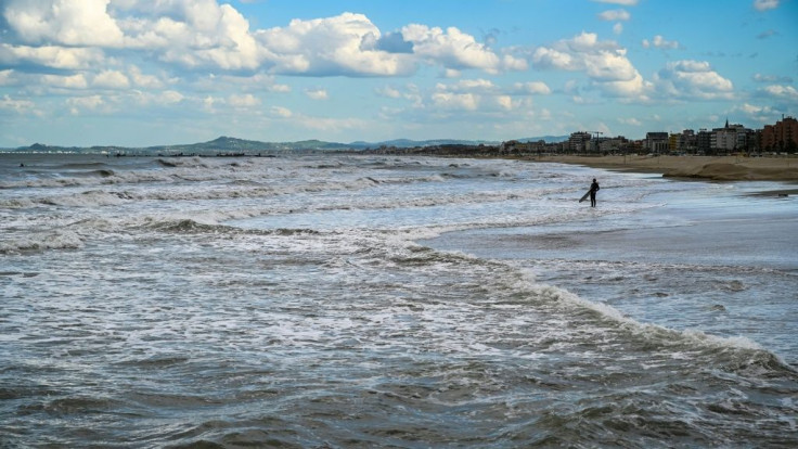 Only a few surfers take the opportunity to hit the waves in Rimini