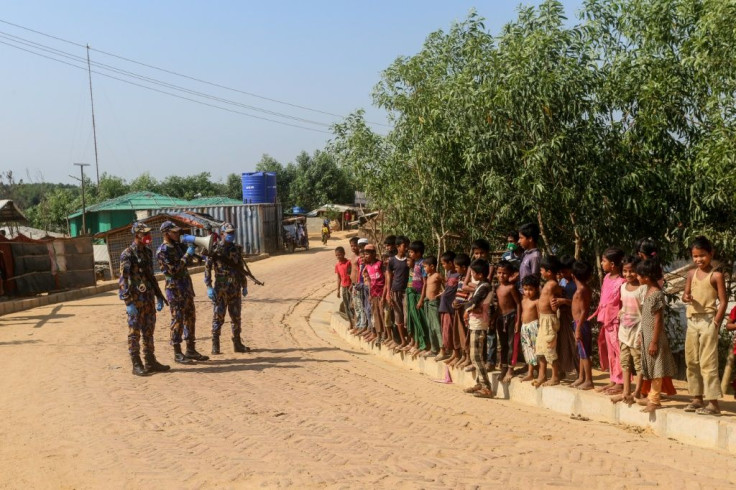 Security personnel use a loudspeaker to raise awareness about the coronavirus in a Rohingya refugee camp in southeast Bangladesh