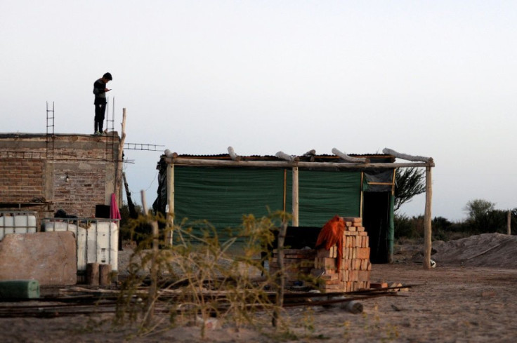 Caye Jofre, 18, stands on the roof of his house near San Jose in Argentina's Mendoza province, trying to get a telephone signal