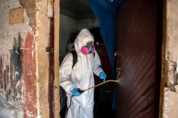 A municipal worker sanitizes the home of Haitian migrants in Santiago, amid mandatory total quarantine due to COVID-19
