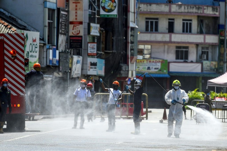 Firefighters spray disinfectant to sanitize a road as a preventive measure against the coronavirus in Colombo, Sri Lanka on May 10