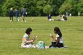Two women enjoy a drink in the grass in London's Hyde Park, opened for the first time in months
