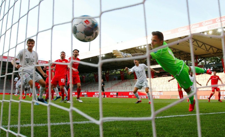 Bayern Munich's French defender Benjamin Pavard (hidden) scores their second goal against FC Union Berlin during the first weekend of Bundesliga play after a two-month absence due to the novel coronavirus pandemic