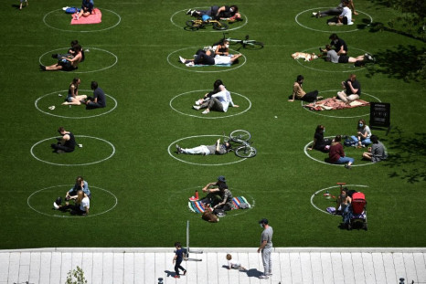 People are seen practising social distancing in white circles in Domino Park in Brooklyn, New York City