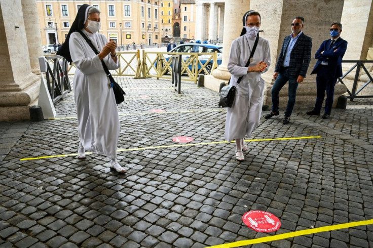 Visitors sanitized their hands and passed through security before entering St. Peter's Square and Basilica