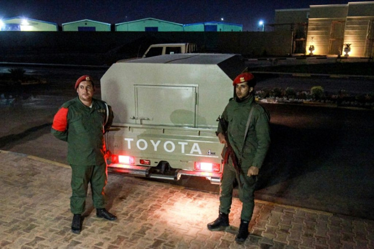 Military police loyal to strongman Khalifa Haftar stand guard earlier this month outside a vehicle allegedly containing arrested Syrian mercenaries