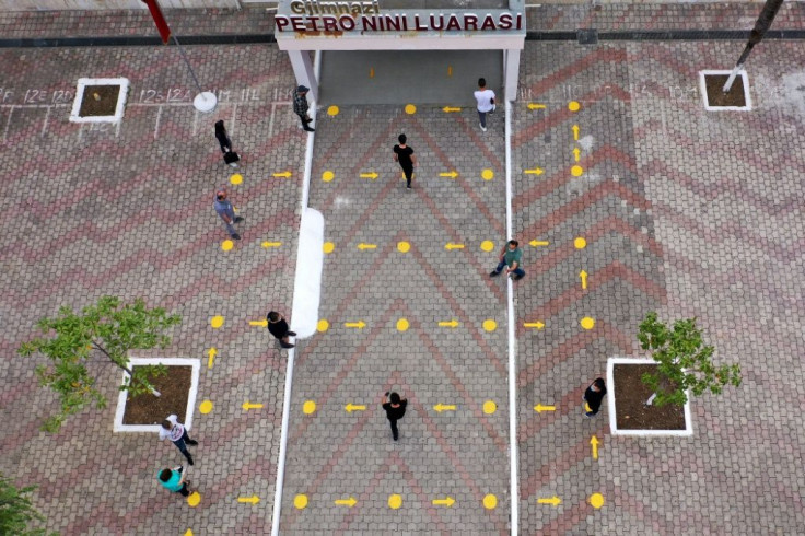 Students follow social distancing guidelines as they enter a school in Albania