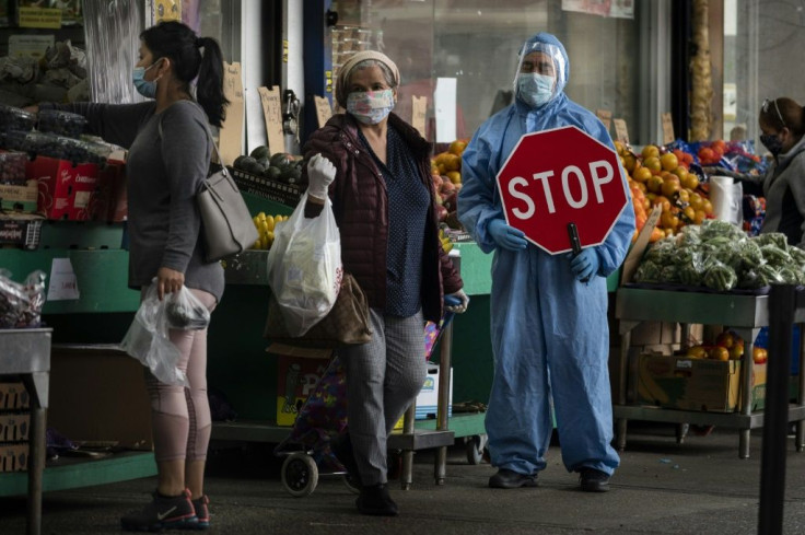 A worker manages the flow of customers into a Food market in the Jackson Heights neighbourhood of Queens in New York City