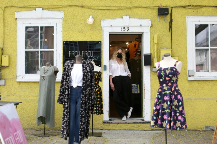 Boutique owner Pat Phythian stands in the doorway of her as she waits for customers Ottawa, Ontario, as Canada's most populous province allows stores with street access to reopen after two months of coronavirus lockdown