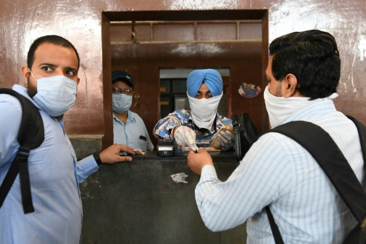 Passengers buy bus tickets in Amritsar as public bus services resumed in India's Punjab state on May 20, 2020