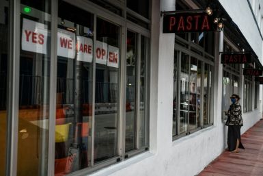 A woman wearing a face mask orders food at the window of a restaurant in Miami Beach -- south Florida is slowly reopening