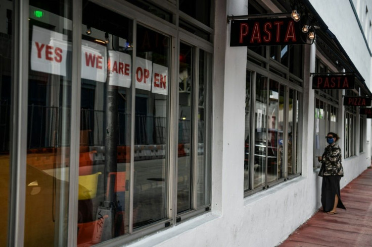 A woman wearing a face mask orders food at the window of a restaurant in Miami Beach -- south Florida is slowly reopening