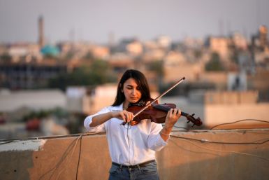 Fadia Khalil, a 22-year-old member of  the Iraqi National Symphony Orchestra, plays violin on the roof of her house in Baghdad
