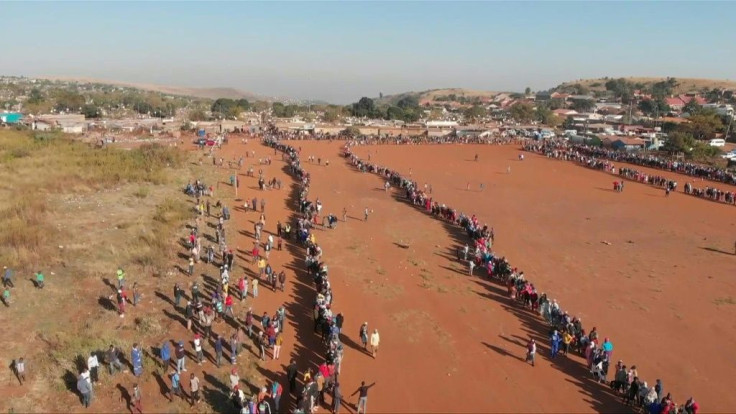 Thousands of people queue up in the early morning in the informal settlement of Iterileng, Pretoria, to receive food hampers, masks, soap and hand sanitiser during South Africa's coronavirus lockdown.